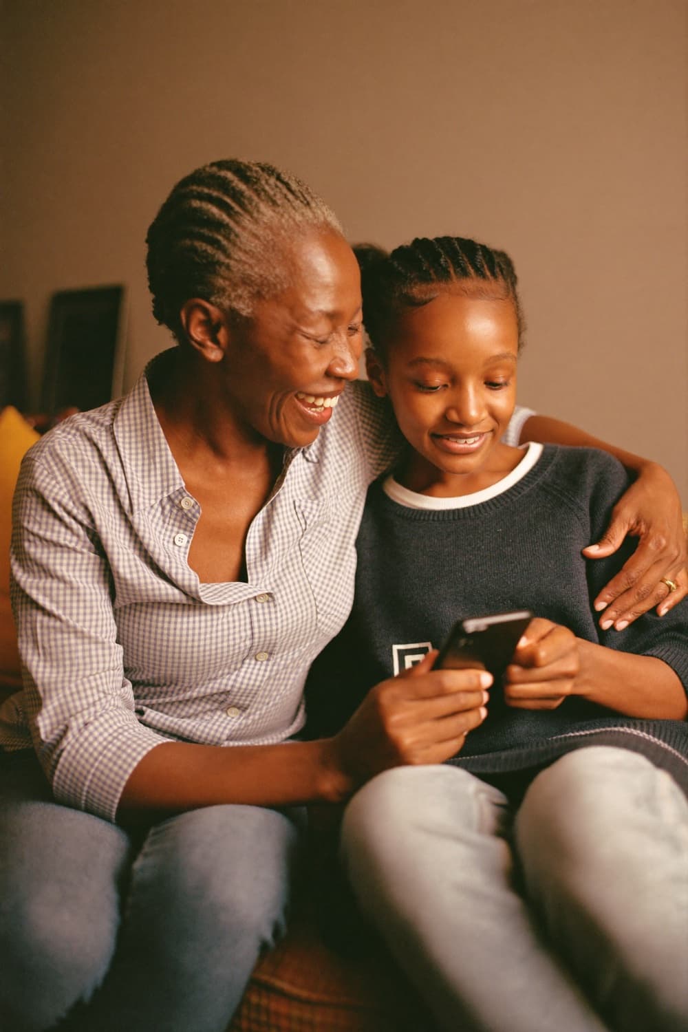 A parent and teenager looking at a phone together